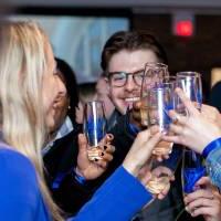 Grads clinking their champagne glasses together.